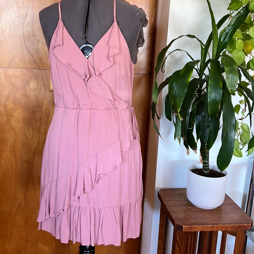 Beautiful blush wrap dress with ruffle detail and racer back.